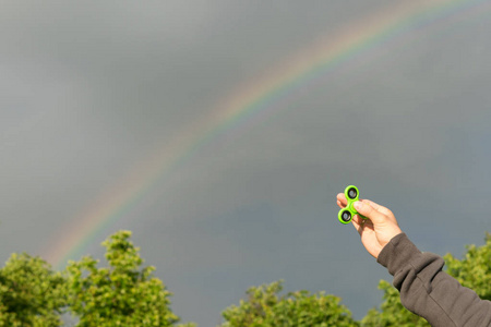 对阴暗的灰色天空手捧微调对彩虹在灰色的天空照片