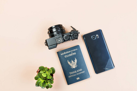 平躺，将复制的老式紧凑型数码相机小仙人掌上柔和的黄色背景与泰国官方护照和智能手机的设计工作空间