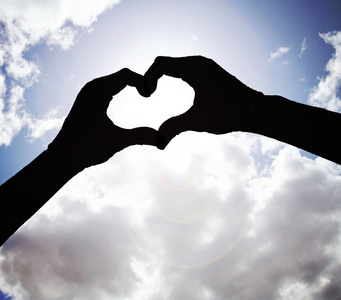 两只手,在天空的心的形状照片
