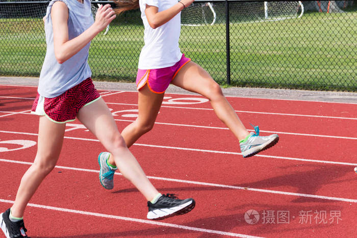 两个高中女生做跑步练习上了红色的轨道