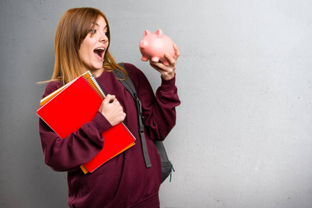 学生手持储钱灰色背景的女人