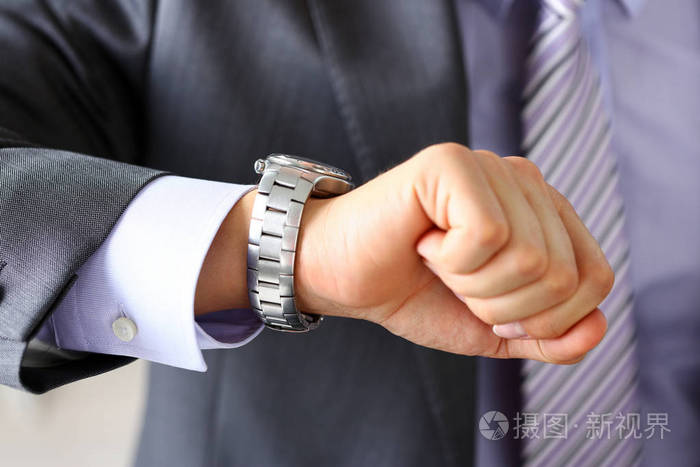男人穿西装打领带退房时间在银色手表