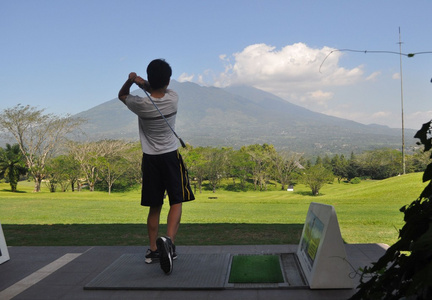 青少年打高尔夫球面临山图片