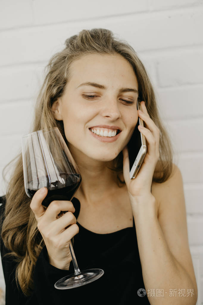 女人用手拿电话的酒