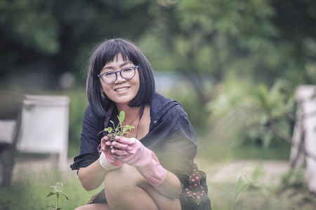 亚洲女人在家里的花园里种植有机蔬菜