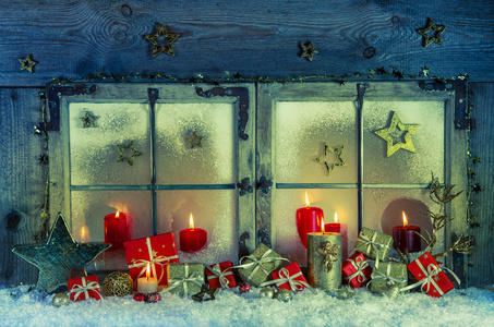 老木窗口为圣诞节装饰红蜡烛与 p