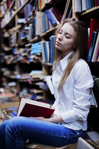生活方式的一个可爱的学生女孩在老式图书馆或书店的肖像