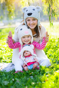 幸福的母亲和女儿在公园里戴着一顶针织的帽子
