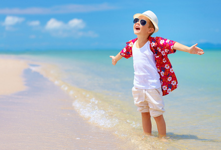 快乐的时尚男孩喜欢夏天海滩上的生命