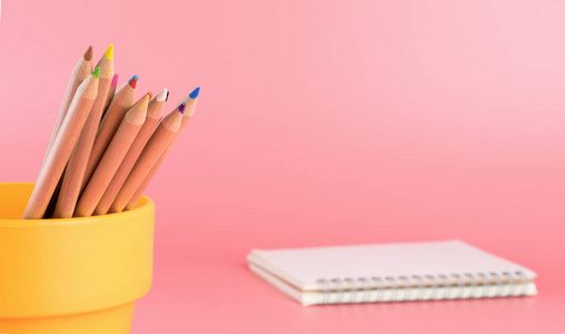 彩色铅笔在斗与笔记本在背景副本空间
