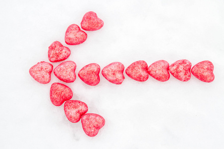 粉红色的心，在雪中的箭头