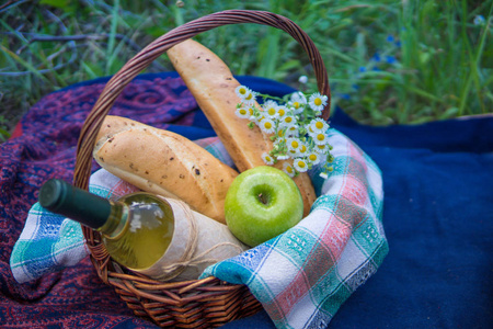 野餐篮与白葡萄酒 两个法式长棍面包 青苹果和