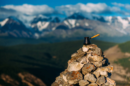 喝咖啡与令人惊叹的山景。美丽的喜马拉雅山景观与咖啡杯和 cezve。外喝着咖啡的雪域景观背景上