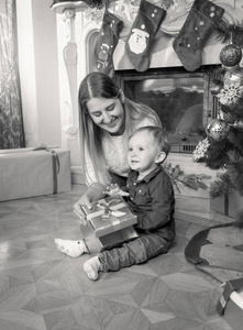 黑色和白色的快乐年轻的母亲和 1 岁的婴儿照片