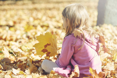 女孩笑着，在秋季就自然漫步在户外嬉戏