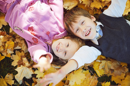 男学生和小女孩笑着,嬉戏性质的秋季户外走走照片