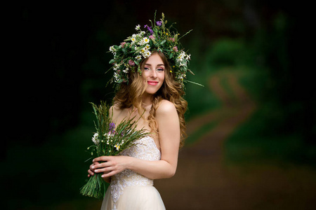 美丽的新娘在鲜花花圈白色礼服图片