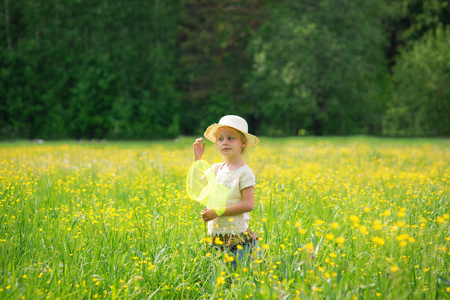 快乐的小女孩与蝴蝶净走在一片草地上在一个晴朗的天
