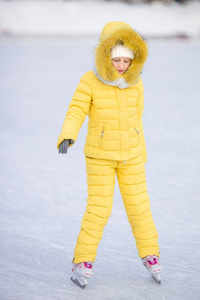 可爱的小女孩去滑冰在冬天下雪天在户外