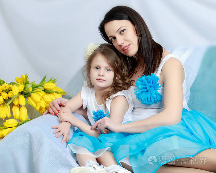 妈妈和女儿在沙发上用一束鲜花