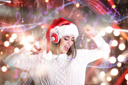 年轻女子戴着耳机听音乐，在模糊的灯光背景。圣诞节和新年歌曲