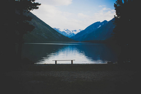 悲观的景观与湖和高丘陵在暮光中的背景