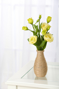 束美丽的鲜花插在花瓶里的窗口背景