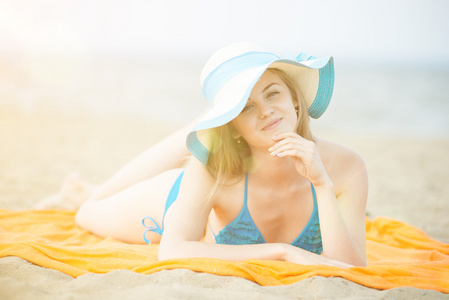 年轻的女士，在海滩上晒日光浴