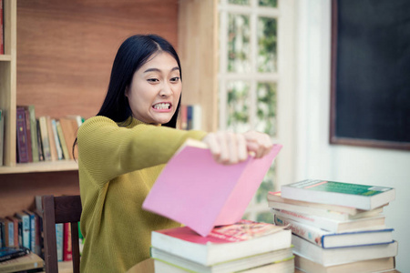 亚洲女大学生在愤怒撕撕她的书照片