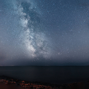 与银河系星空的美丽的风景。在海的夜晚天空背景