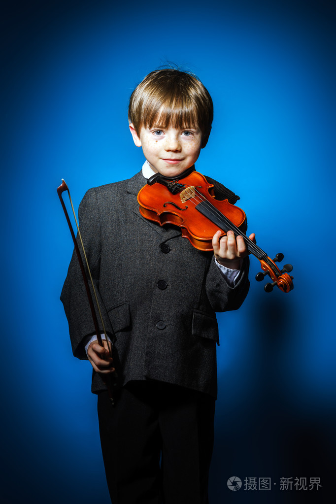 红发的学龄前儿童男孩用小提琴音乐概念