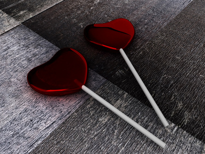 一根冰棒在木制的背景上的一根棍子上的两个红色糖果照片