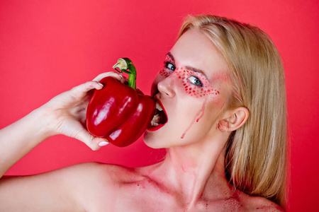 在红色的背景下，心的女人咬辣椒粉