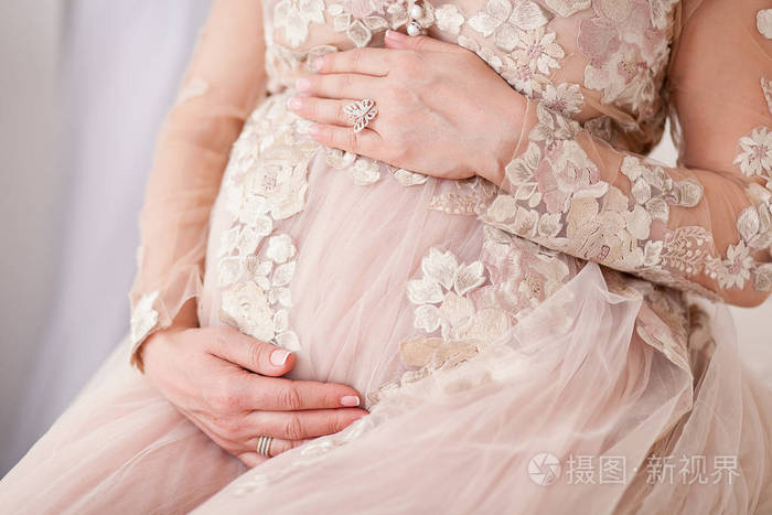 孕妇摸她的肚子用手的特写图片