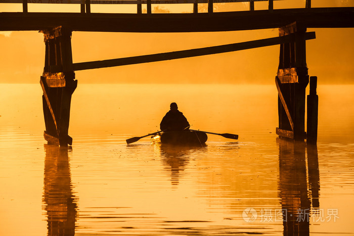 在河边的美丽日落.渔夫是在船上