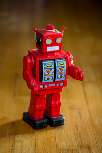 复古红色锡机器人在硬木地板上