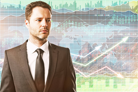 外汇图表背景上英俊年轻的商人的画像.交易的概念照片