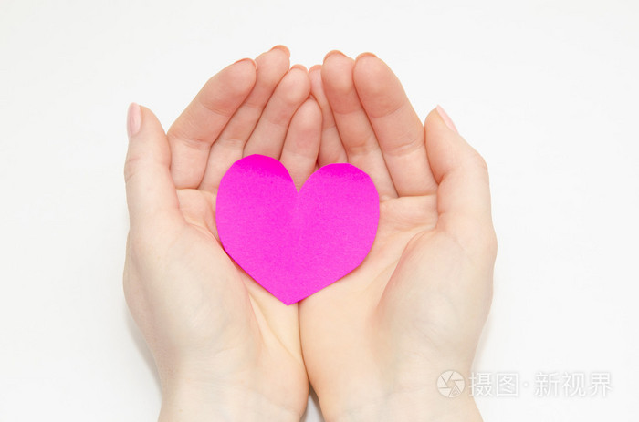 妇女的手里捧着一颗粉红色的心