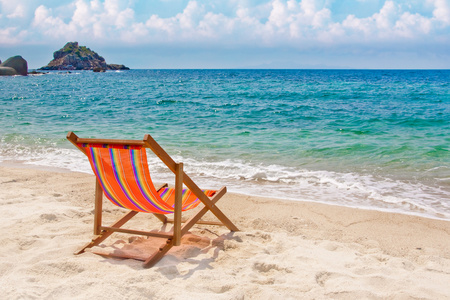 地平线上湾海湾的沙滩上休闲椅照片