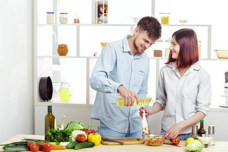 爱幸福的夫妇准备健康新鲜的蔬菜沙拉在厨房