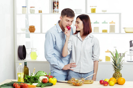 爱在厨房里对幸福的夫妇吃苹果