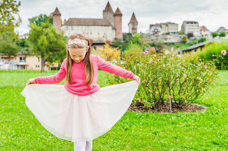 学生鞠躬可爱的小女孩的室外肖像照片