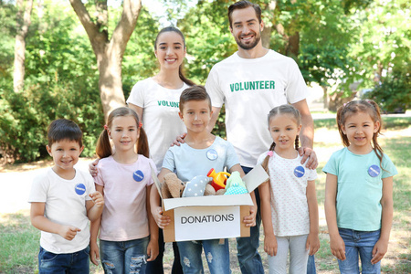 青年志愿者和儿童在户外捐赠箱图片