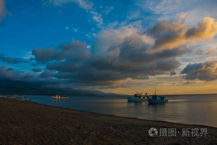 火山的沙滩日落时。海上船舶。香兰，班乃菲律宾