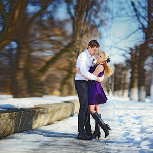 在冬天，快乐的男孩和女孩在雪地上的恩爱夫妻