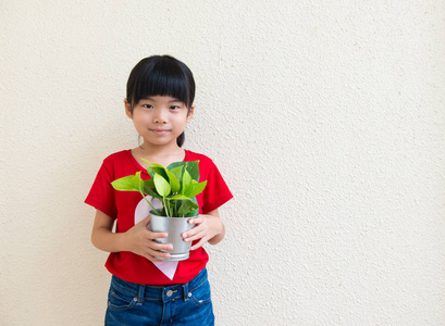 小女孩抱着盆栽的植物图片
