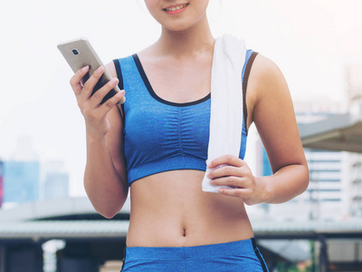 使用智能手机的体育女跑步运动员