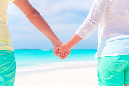 年轻夫妇手牵着手在热带海滩