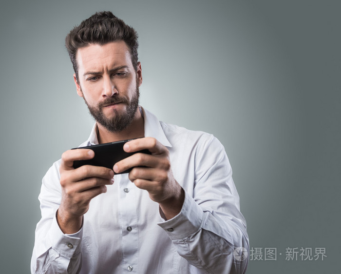 英俊的男人玩智能手机