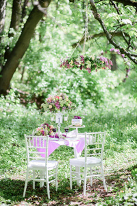 与束紫罗兰色的花和小蛋糕的第一号桌